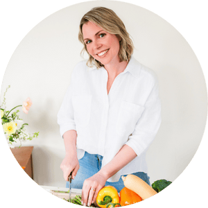 Taesha, founder of The Natural Nurturer, smiling, and chopping vegetables