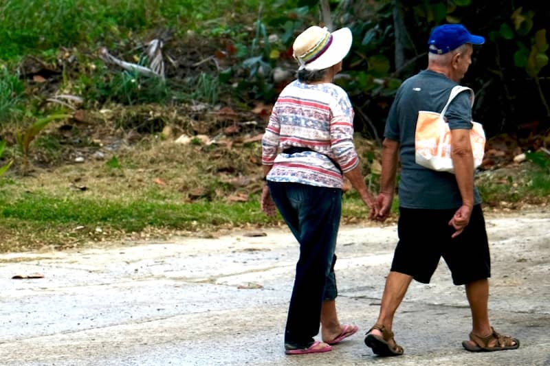 Elderly couple walking hand in hand outdoors