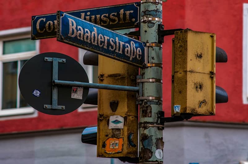 A street sign on a pole in front of a red building