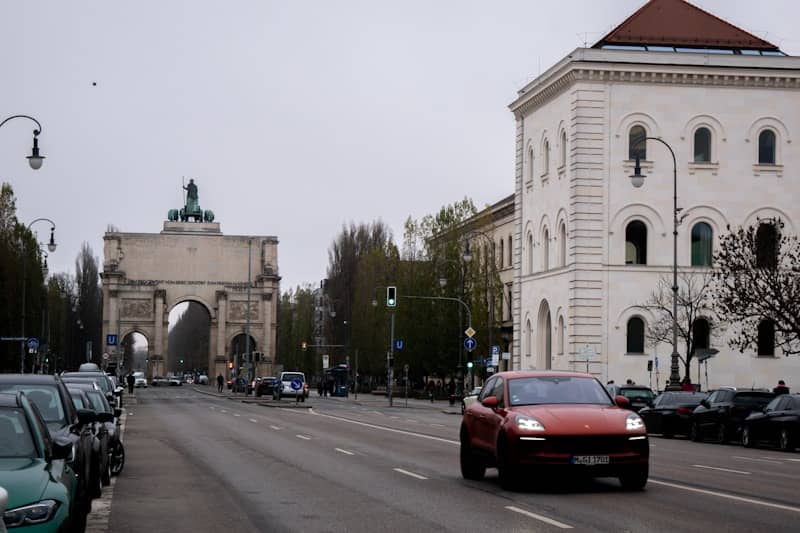 Cars driving on a city street with archway.