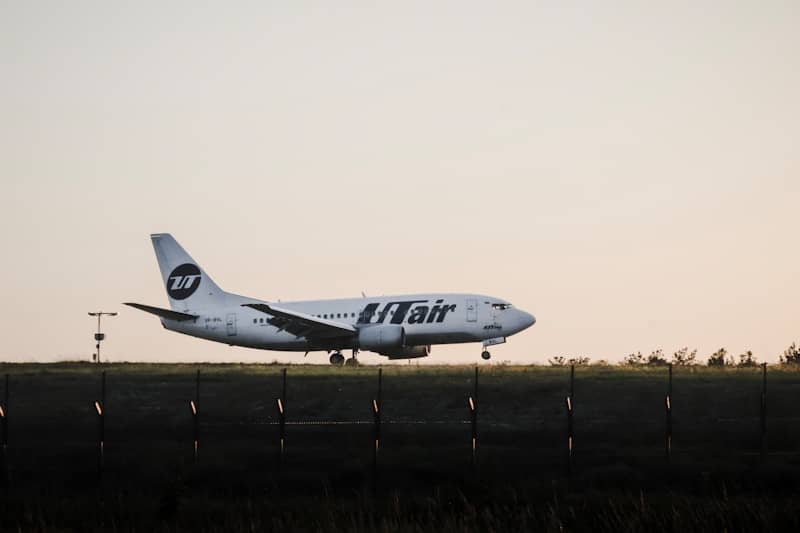 Airplane landing on runway at sunset