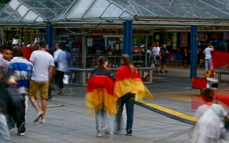 A group of people walking down a sidewalk