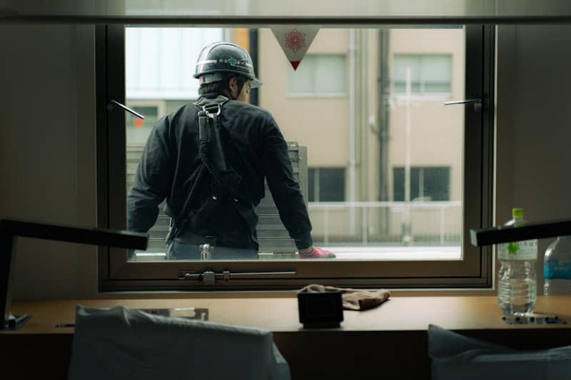 A construction worker looks out the window.