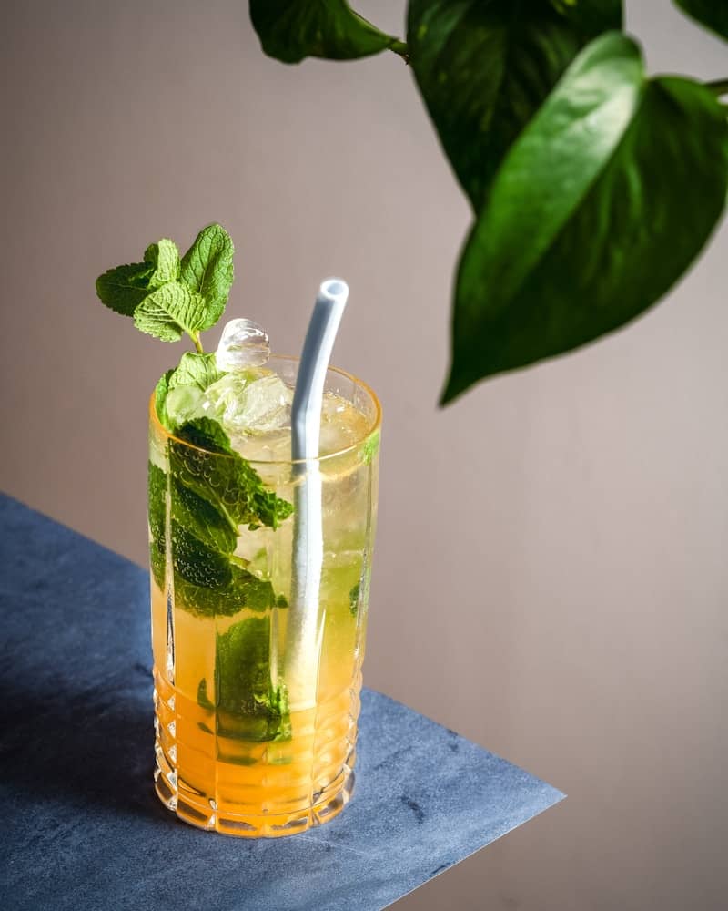 A glass with a drink and a straw on a table