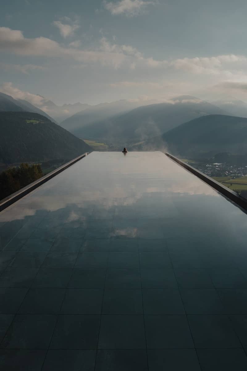 Infinity pool overlooking misty mountains and valley.