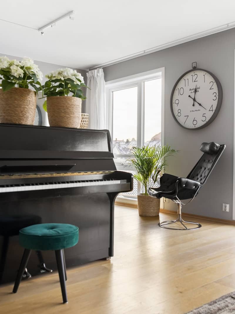 A living room with a piano and a clock