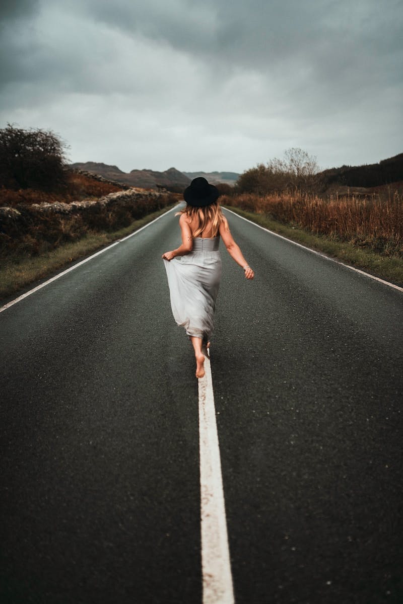 woman in white dress walking on the road