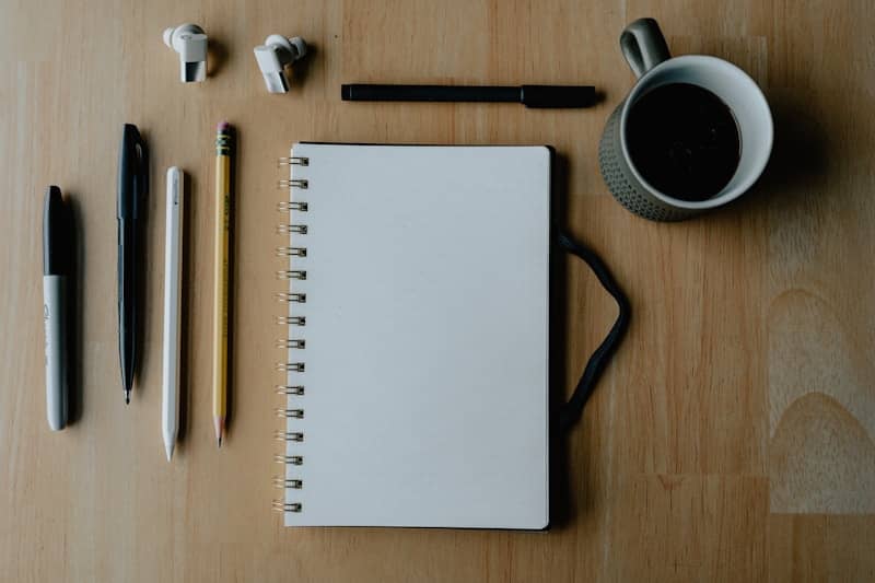 Notebook, pens, pencil, and coffee: ready to write.