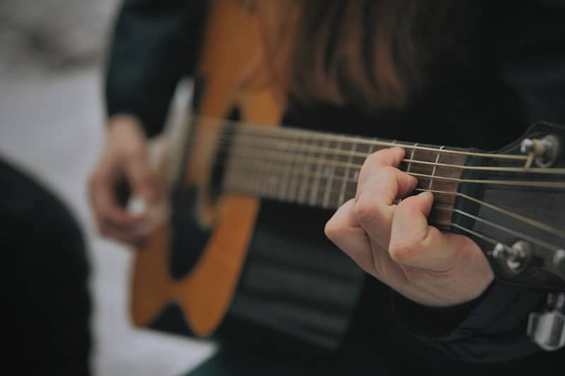 Someone is playing a brown acoustic guitar.