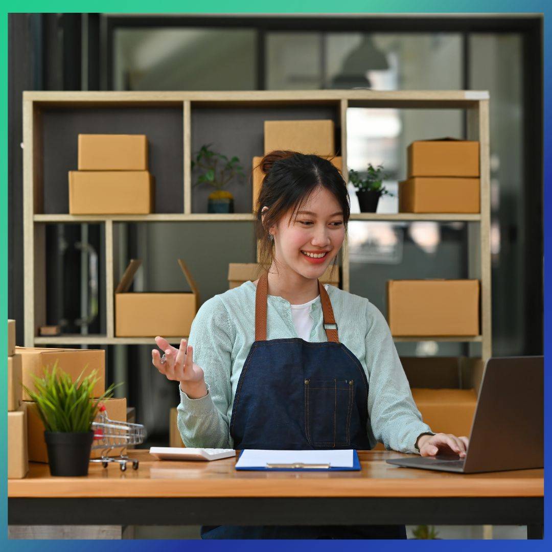 A small business owner looking at the laptop with her products.