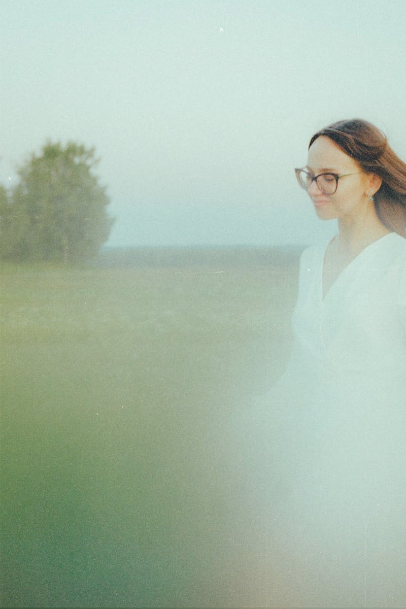 A woman in a field with a frisbee in her hand