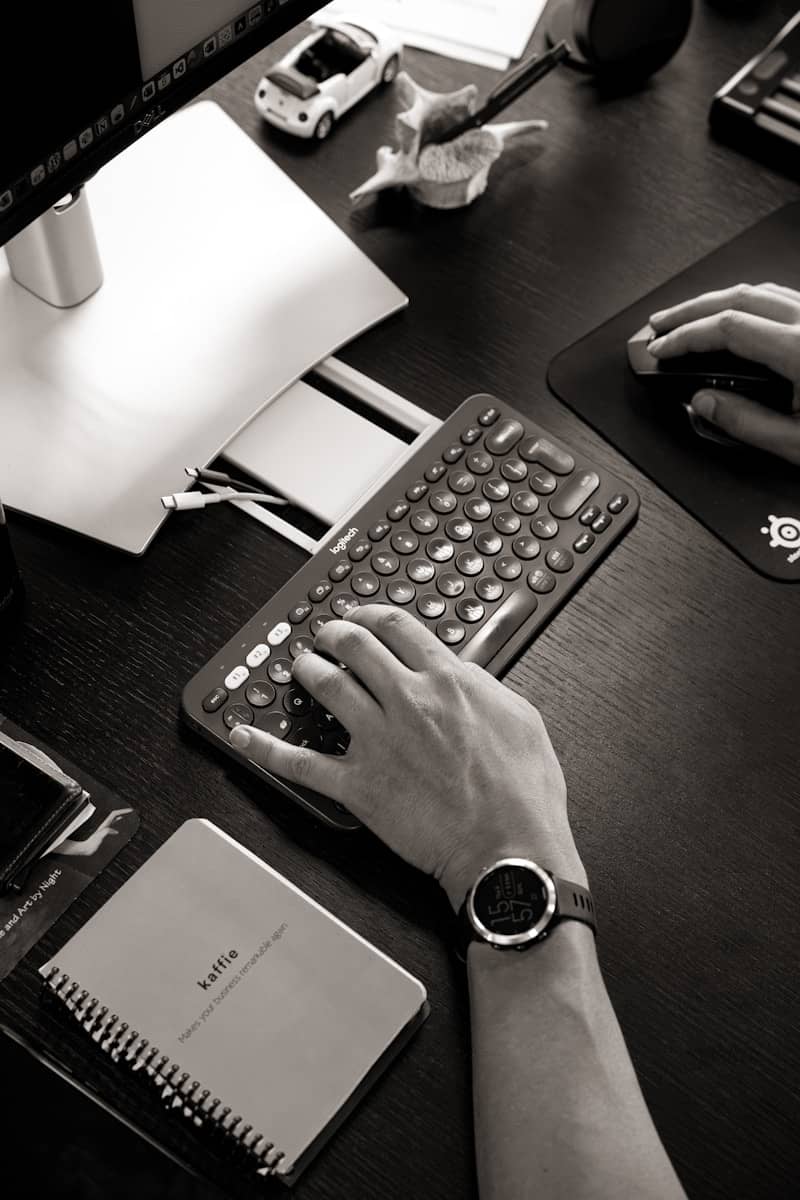 A person typing on a keyboard at a desk