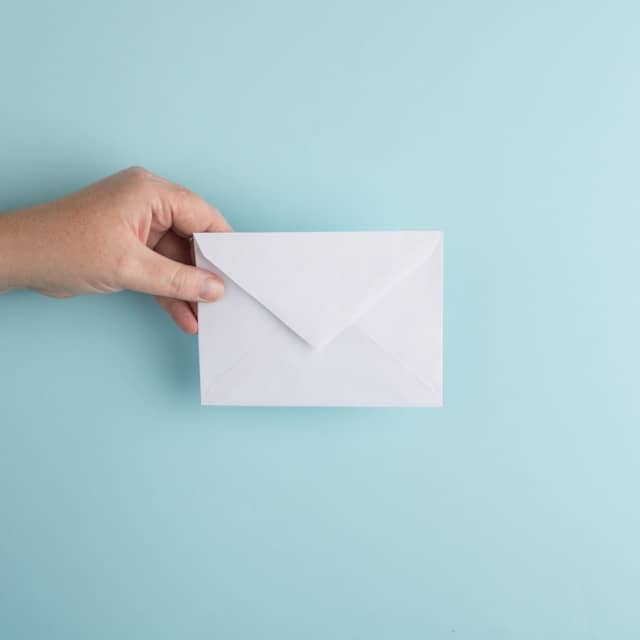 Person holding a white envelope