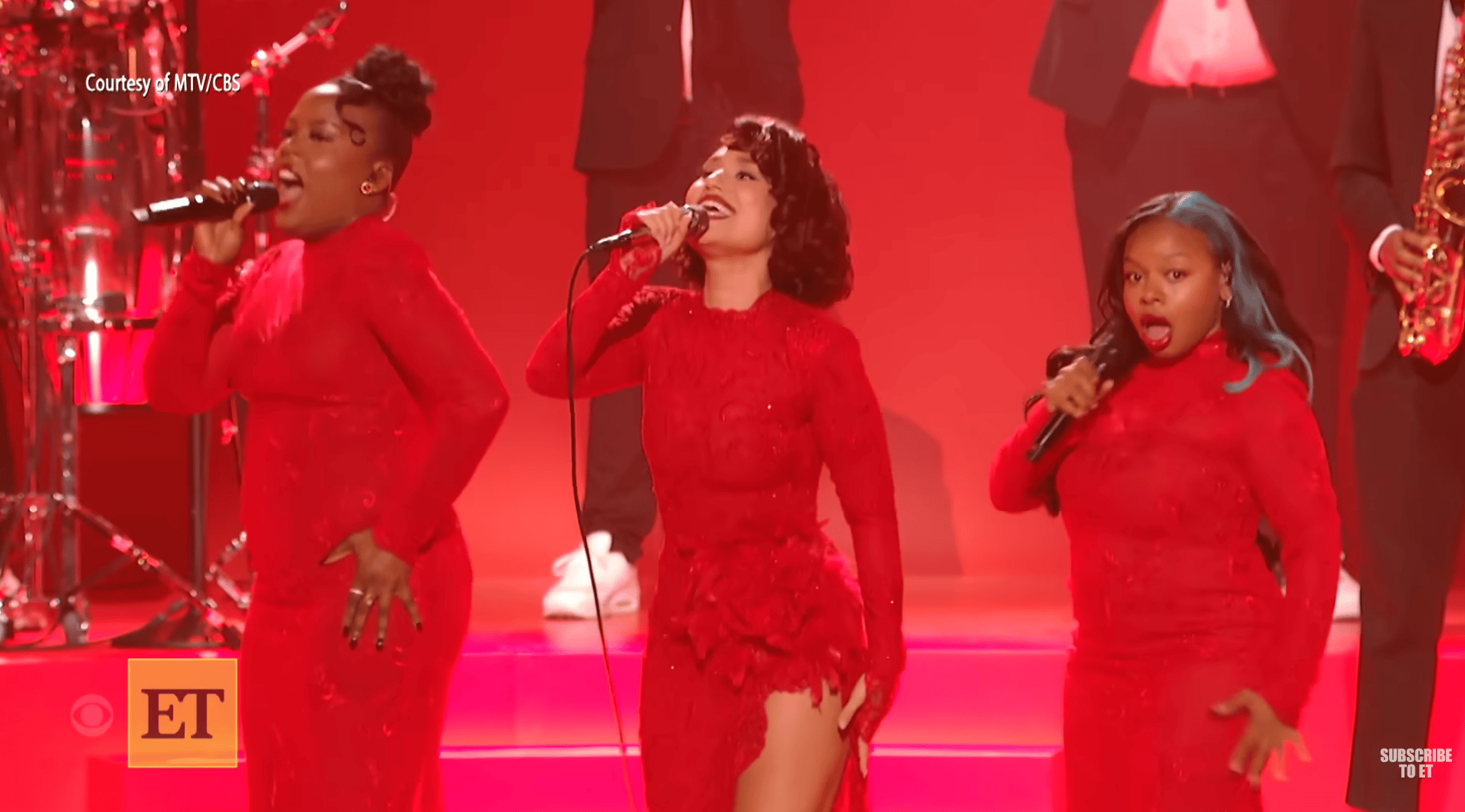 Three women sing wearing right red dresses