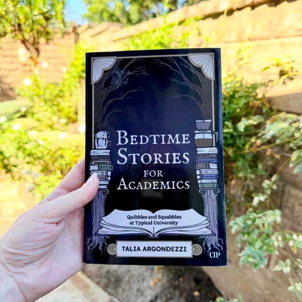 Person holds up a book, titled: Bedtime Stories for Academics