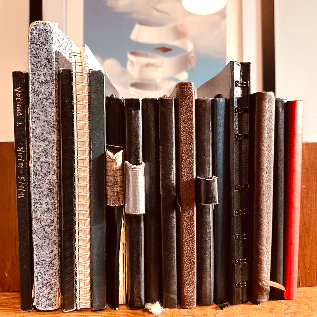Colorful note-taking notebooks out on a wooden desktop