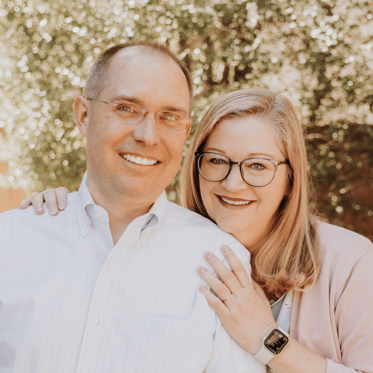 Man and woman wearing glasses smiling warmly