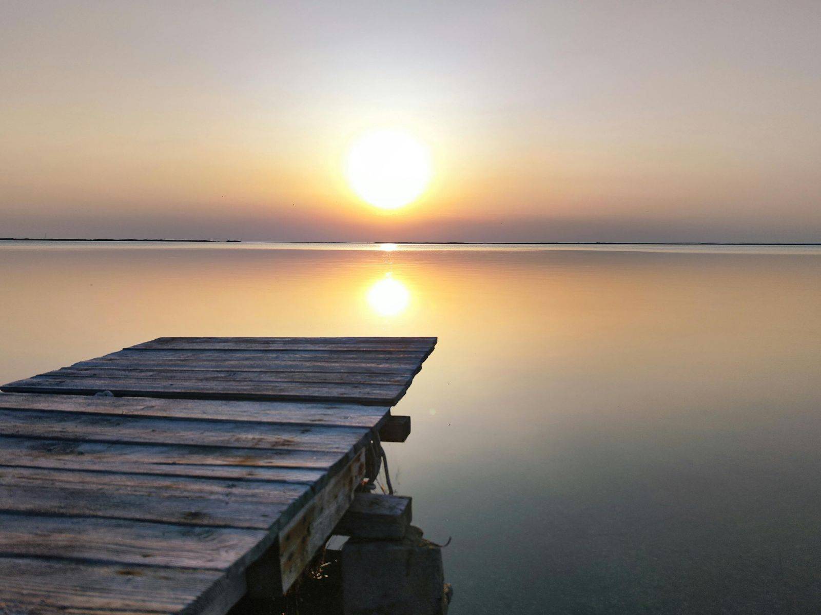 dock on lake with sunrise