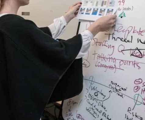 woman in black blazer writing on white paper