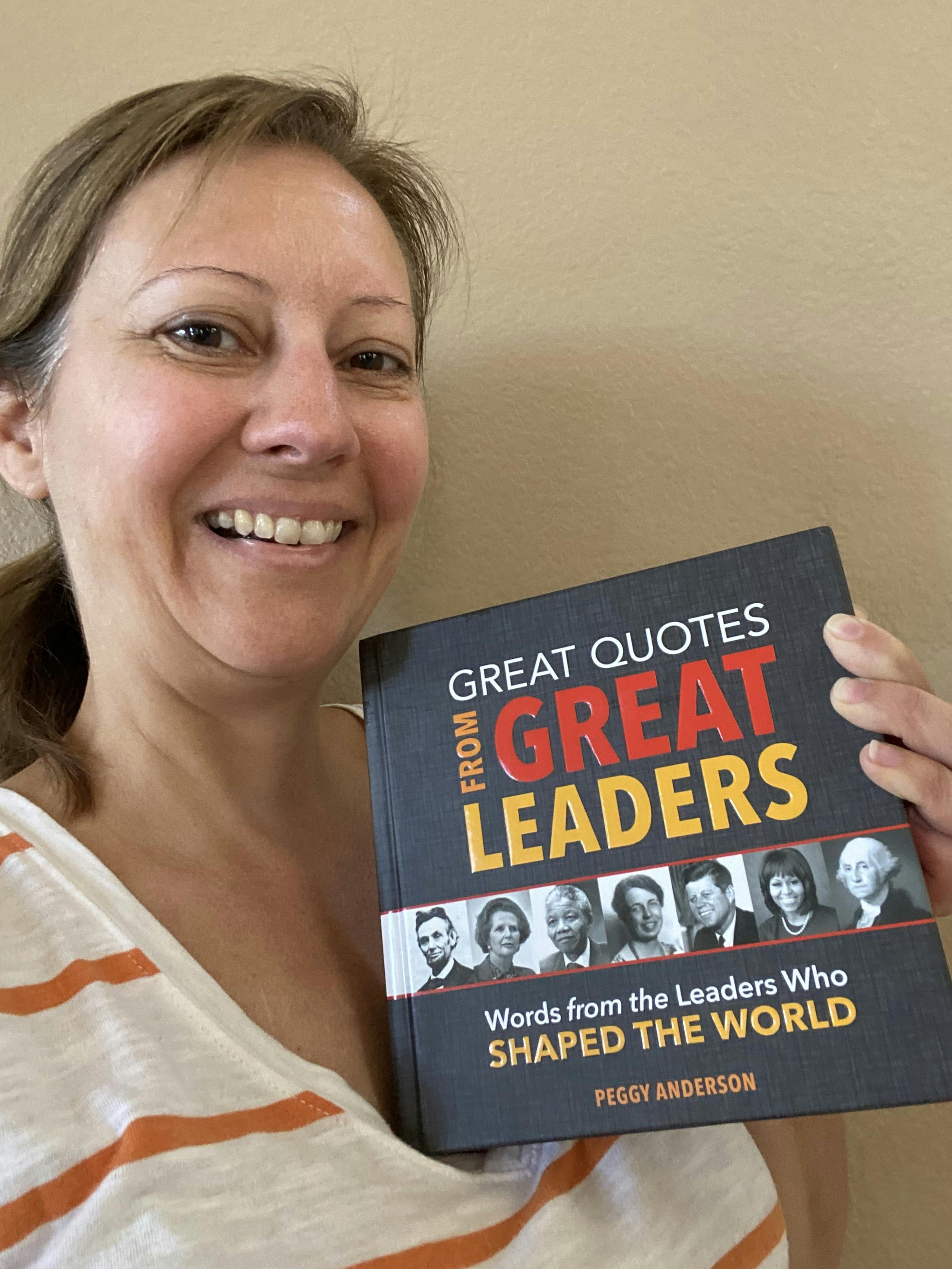 Stephanie holding up the book "Great Quotes From Great Leaders" by Peggy Anderson 