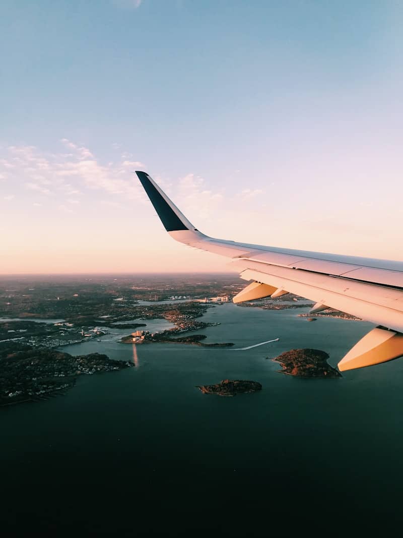 white airplane wing over the city during daytime