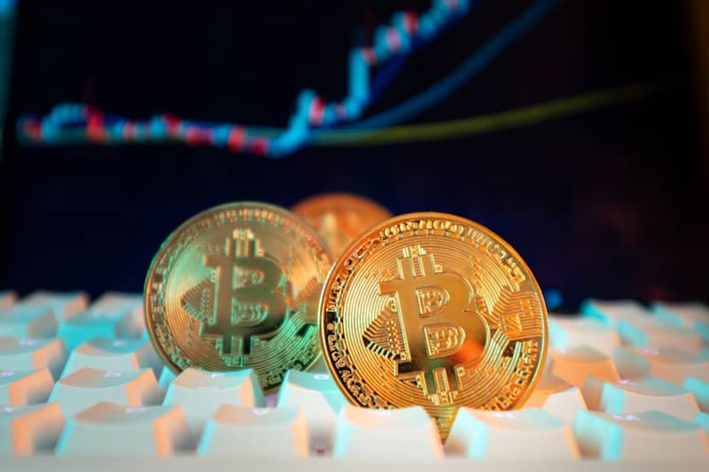 Bitcoin coins are displayed with a stock chart.