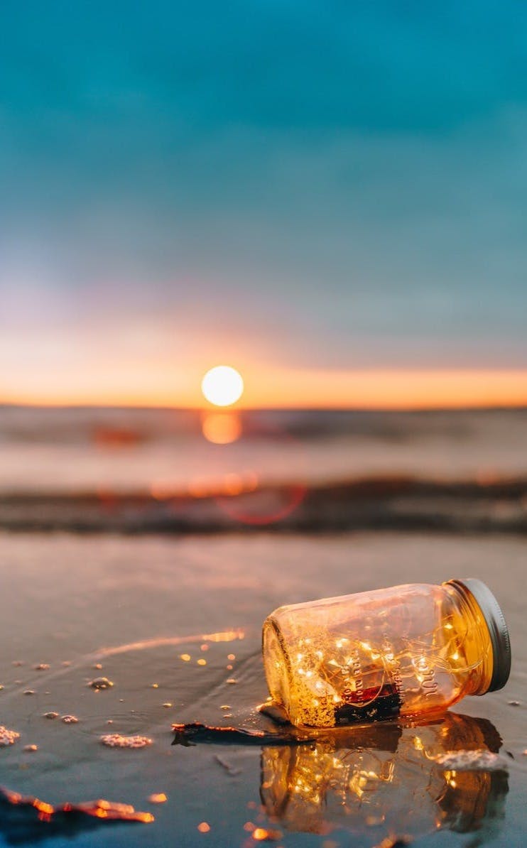 clear glass mason jar on beach during sunset