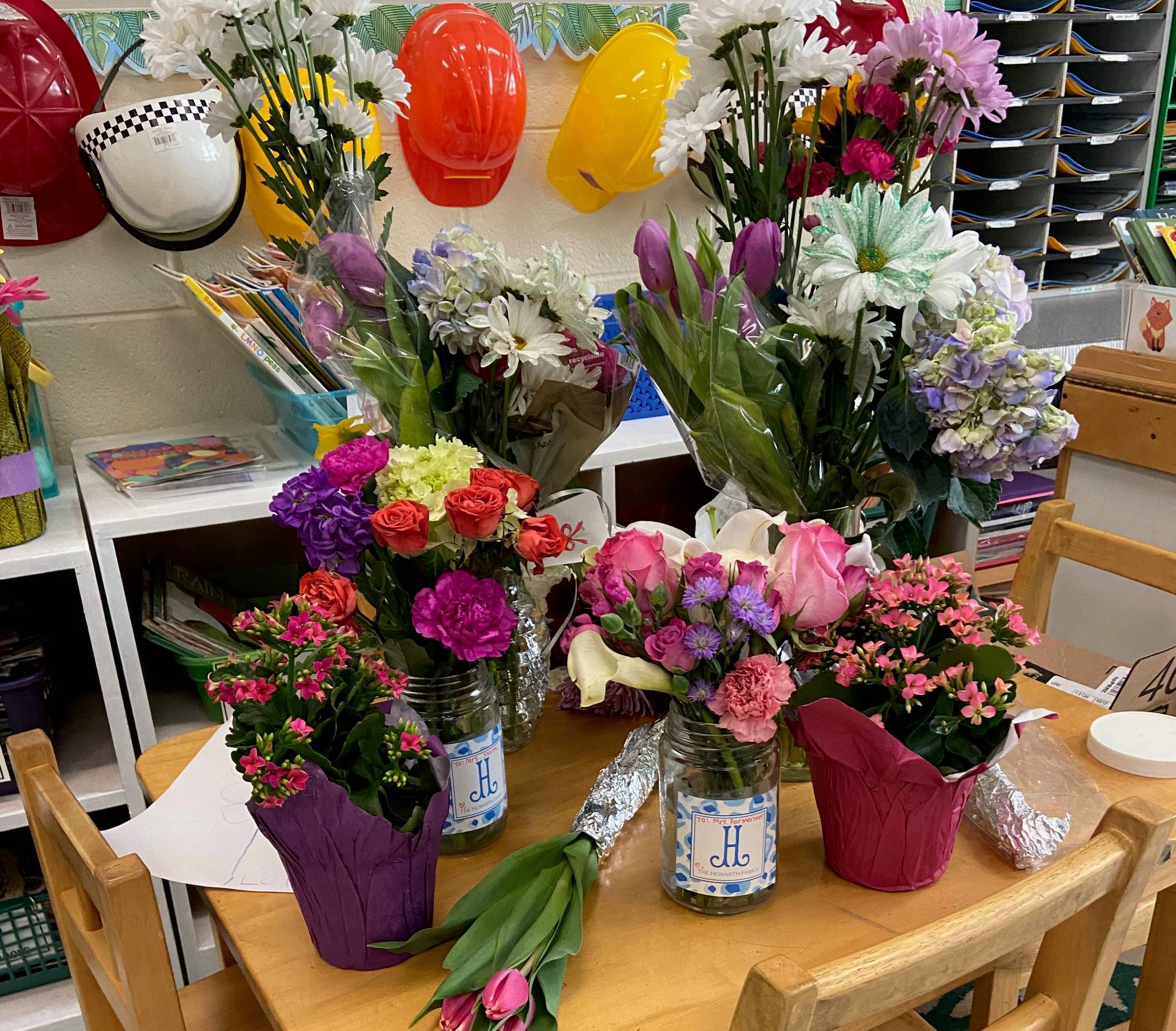 several bouquets of flowers in an elementary school classroom
