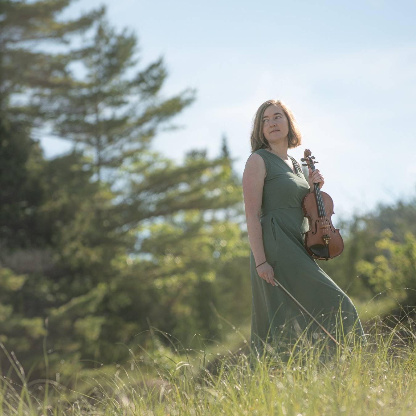 Hannah with her fiddle in the tall grass at Petoskey State Park