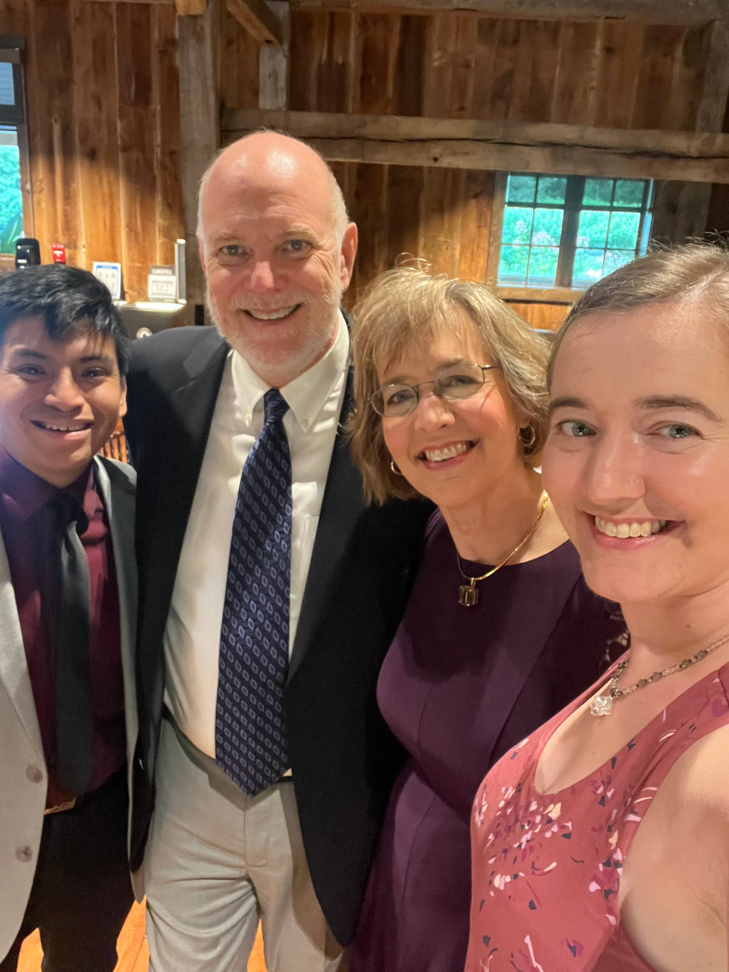 Bear, Hannah, and Hannah's parents smiling together and celebrating family