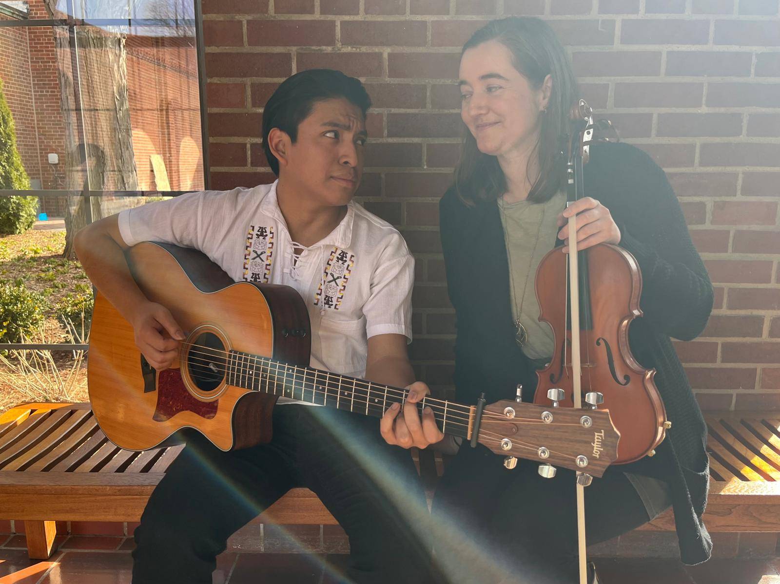 Shannon Lee musicians sitting on a wooden bench at St. John's Resort with their instruments