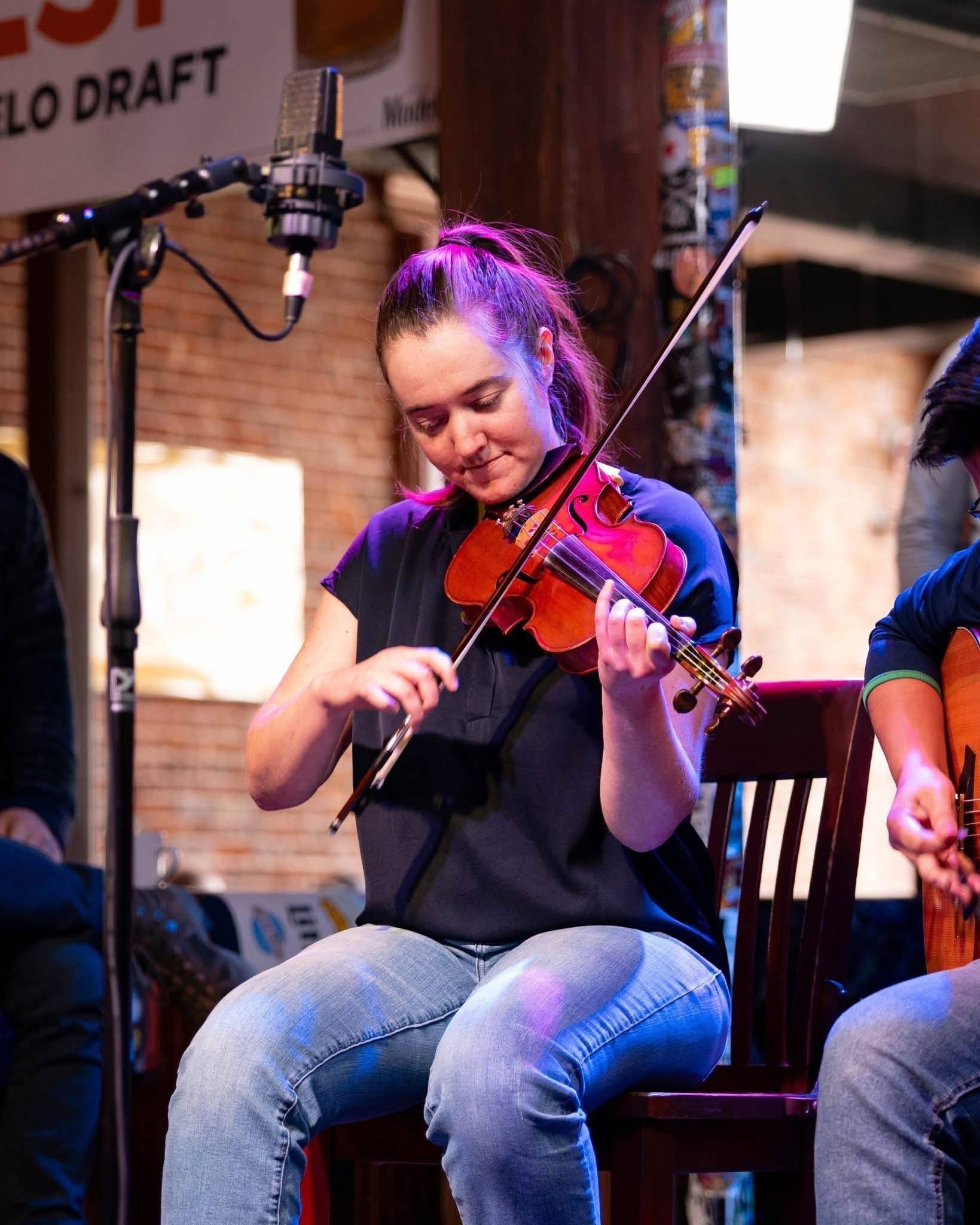 Hannah playing her fiddle for a live show in Knoxville