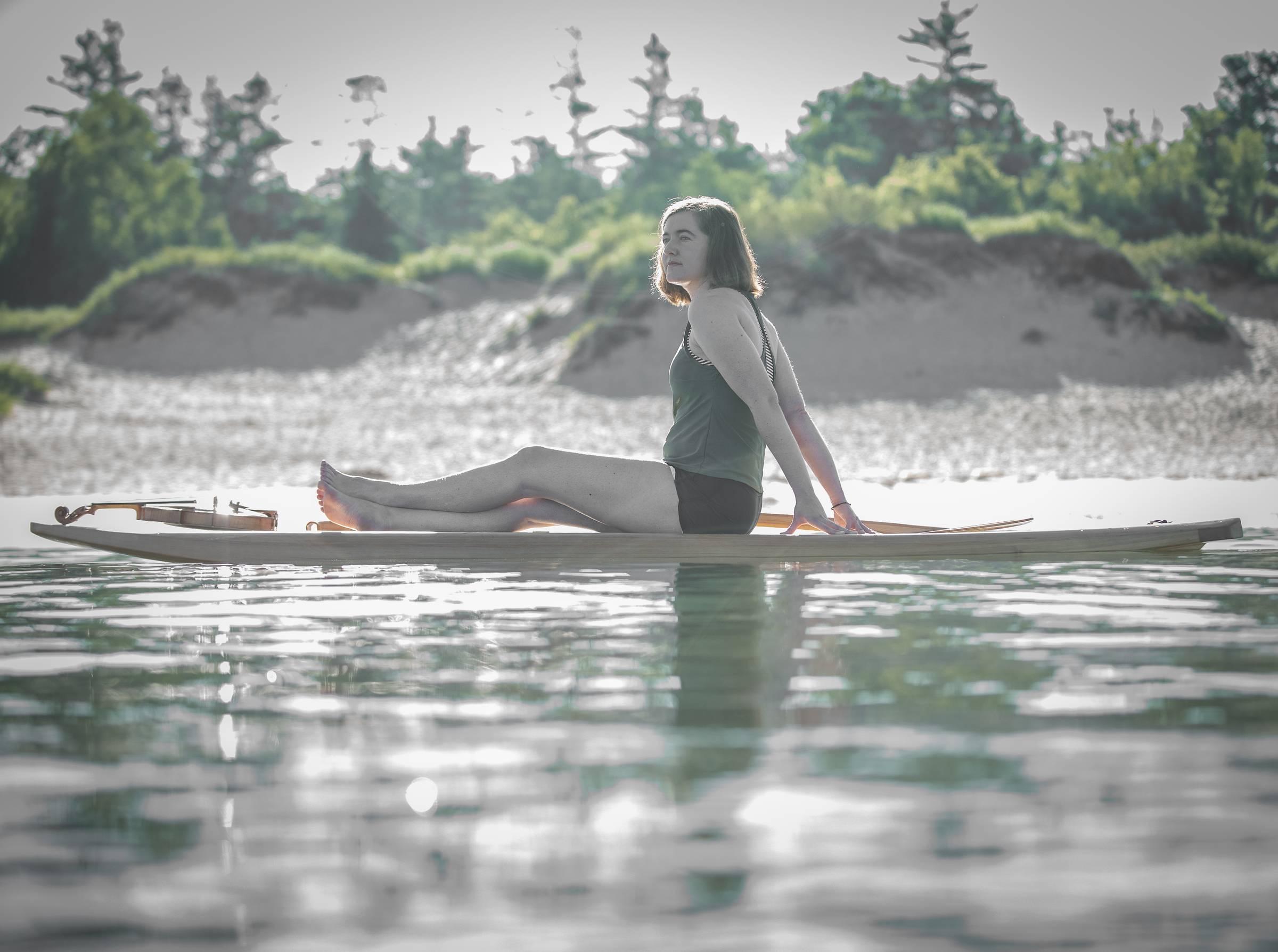 Hannah and her fiddle balanced on a paddleboard in Lake Michigan