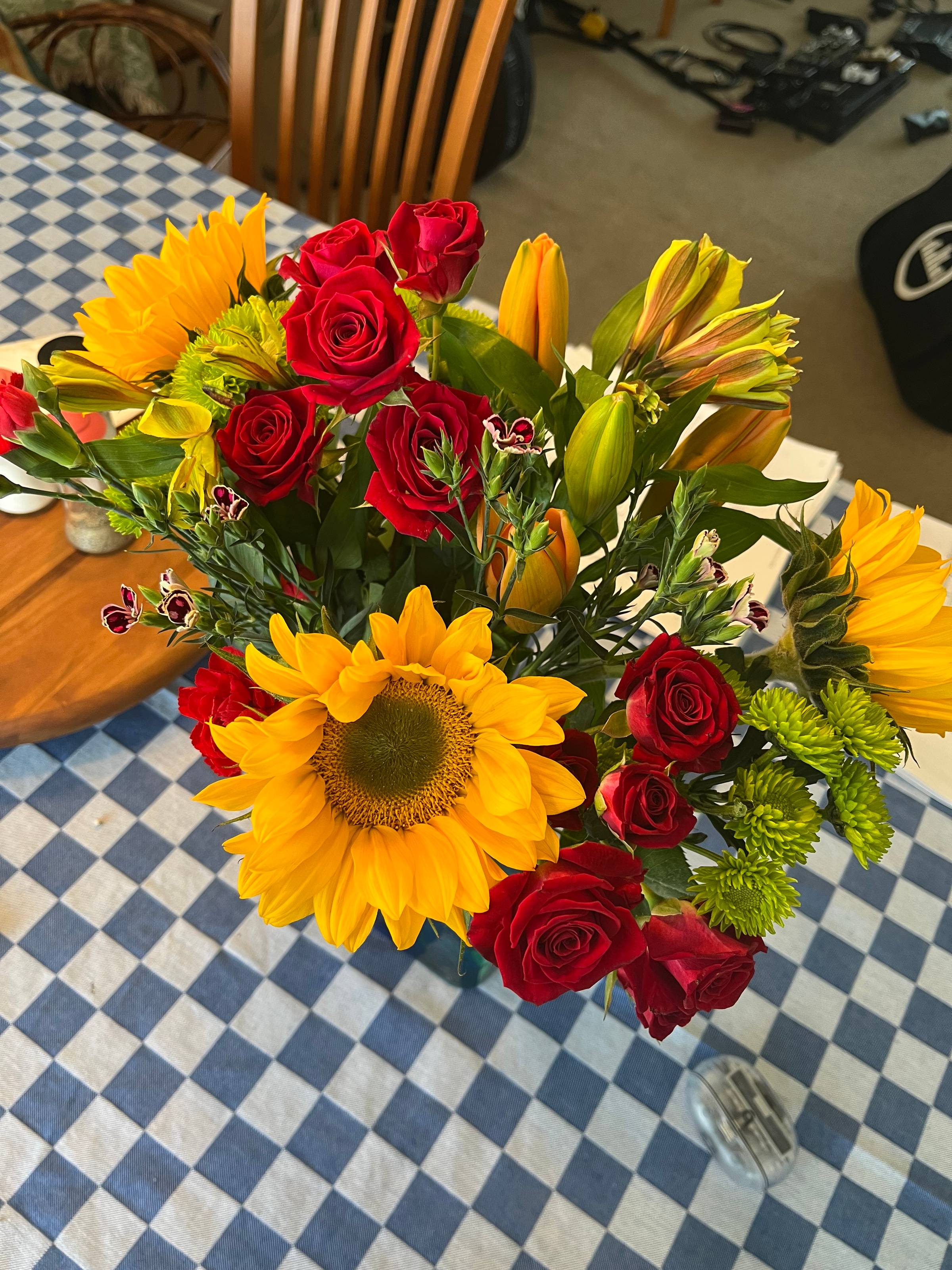 Bright cheerful flowers on a blue and white checked tablecloth