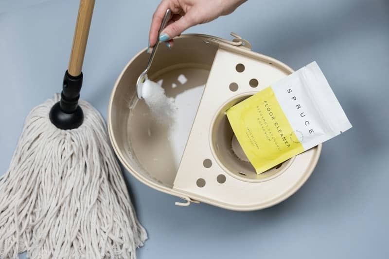 Adding cleaning powder to a mop bucket.