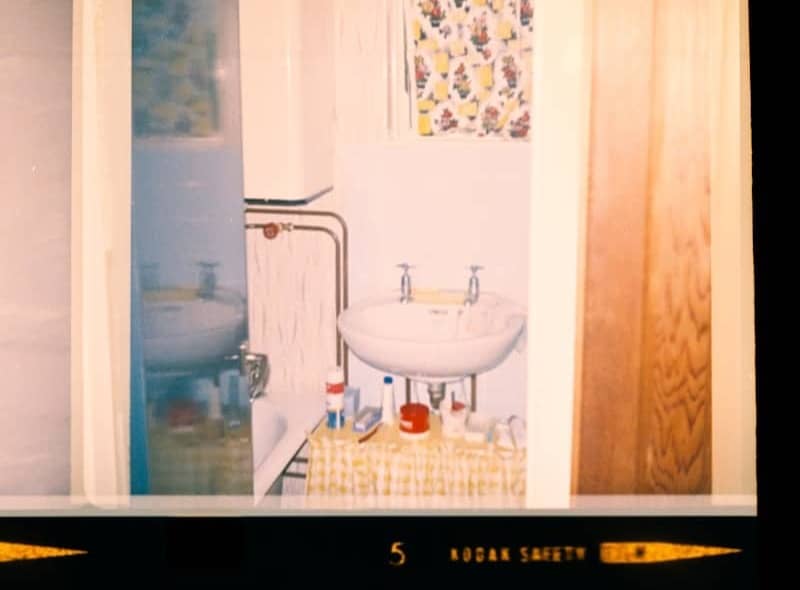 Bathroom sink with toiletries and patterned wallpaper