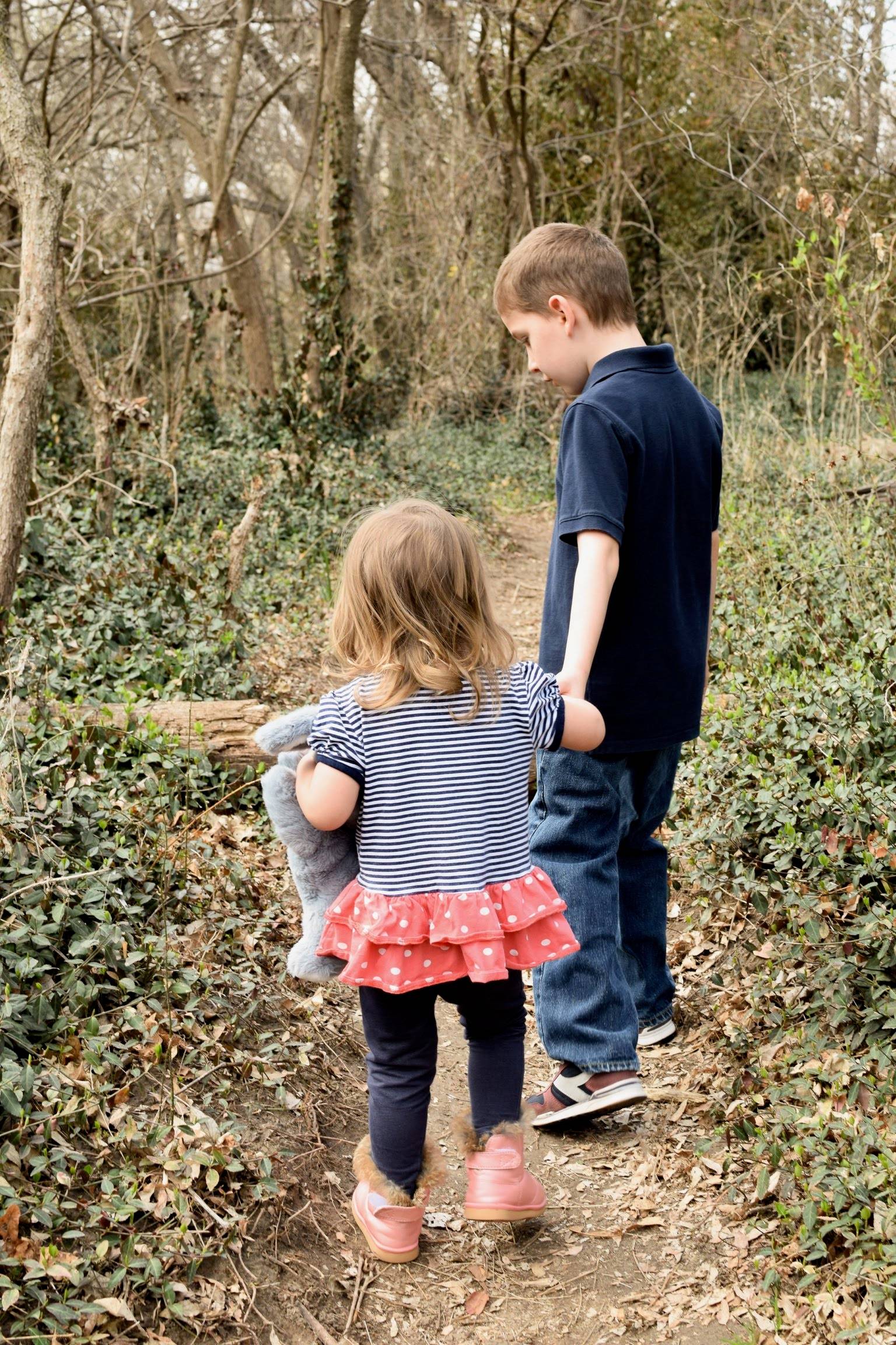 children holding hands in the forest