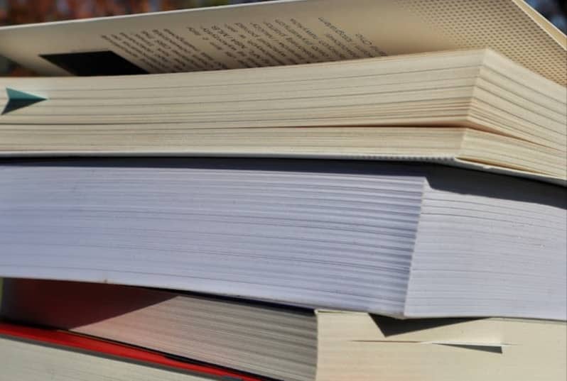 Books stacked on top of each other outside.