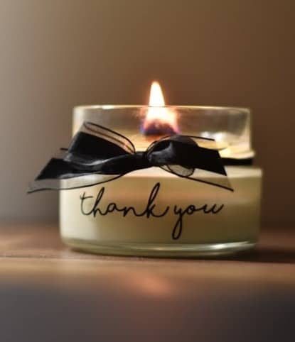 Candle burning in a jar with the word thank you written on it