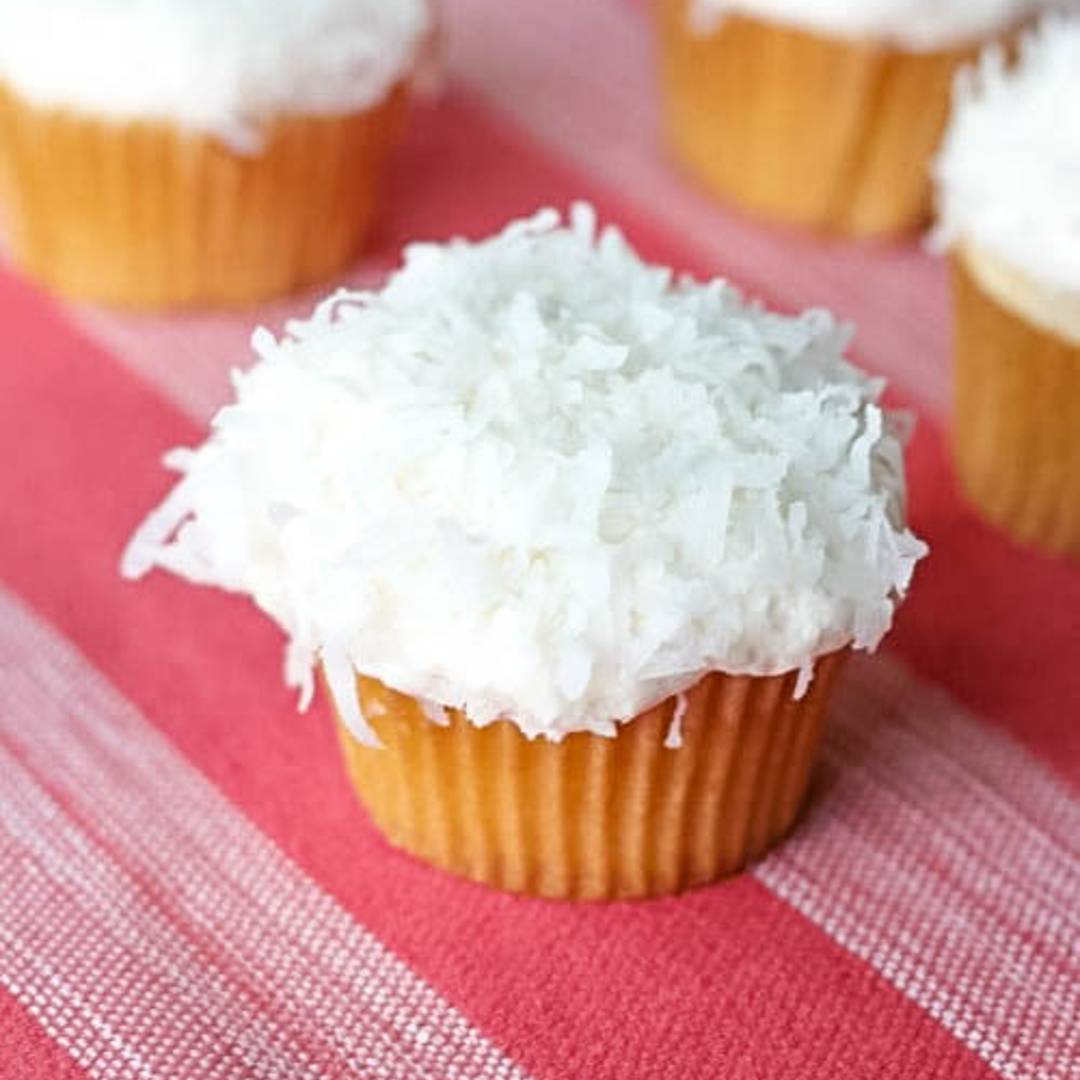 Coconut cream cupcakes with shredded coconut on top. 