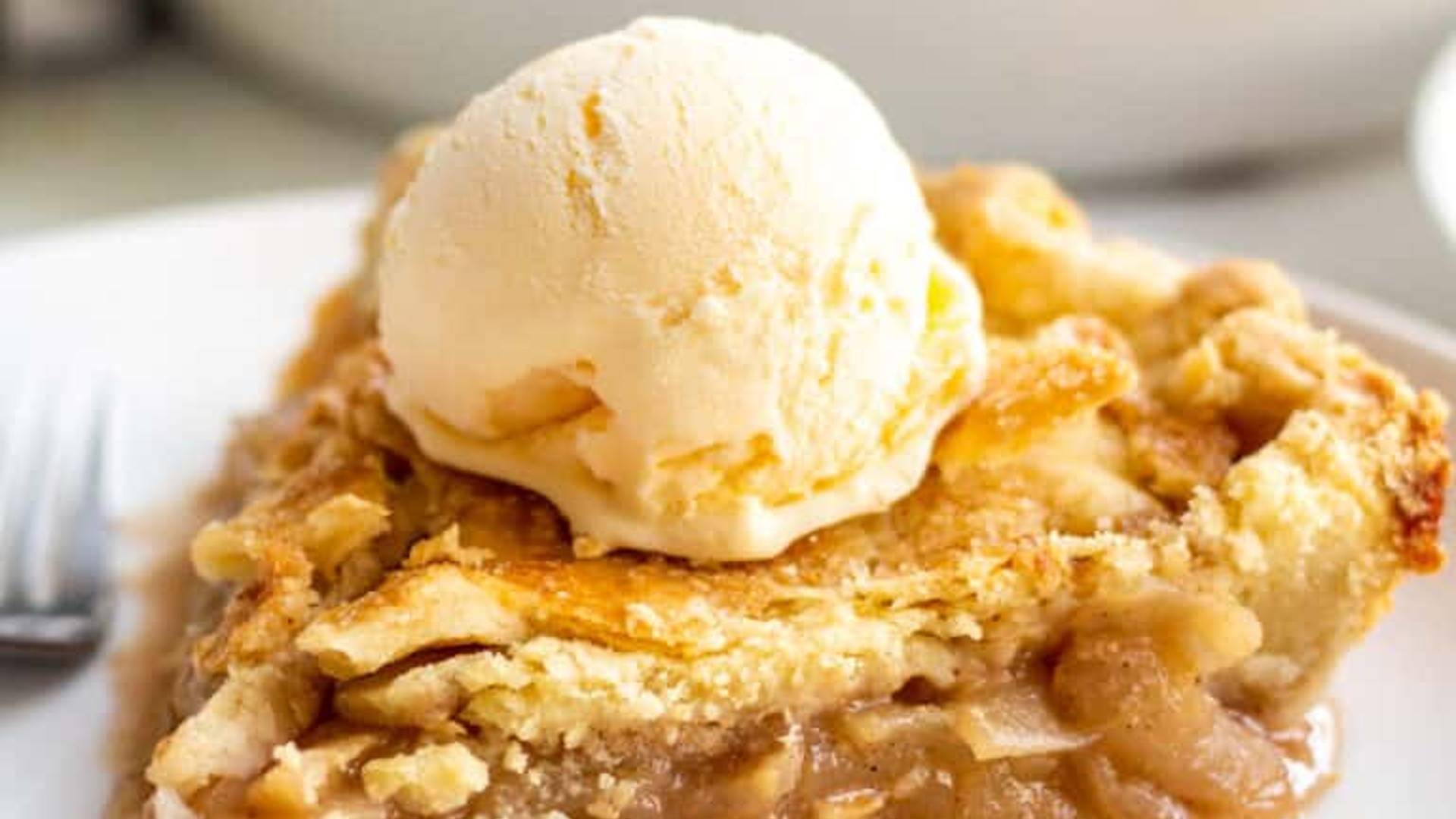 Homemade apple pie with scoop of vanilla ice cream on top. 