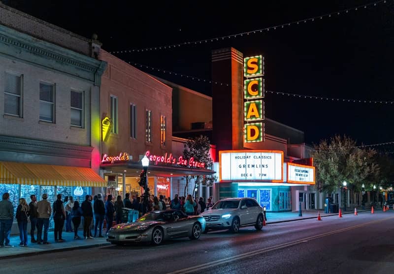 A crowd of people standing on the side of a street