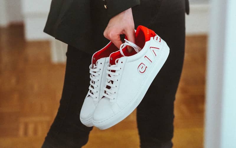 person holding white nike air force 1 low