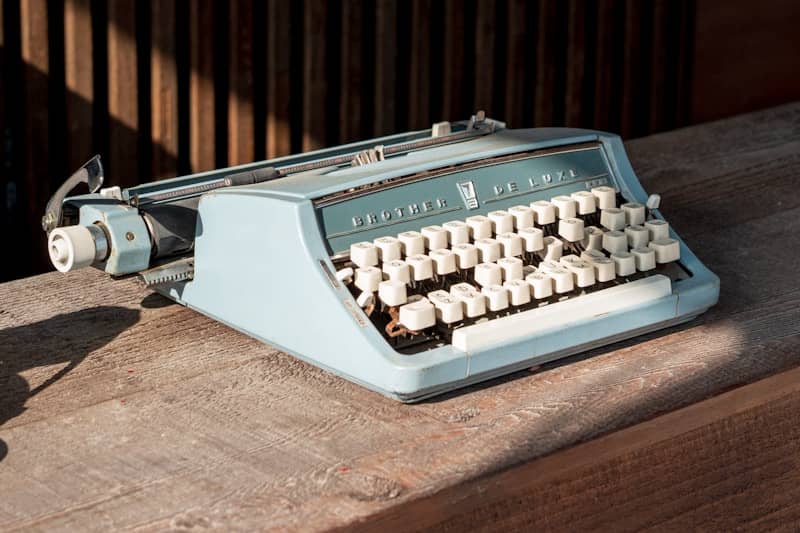 Vintage blue typewriter on a wooden surface.