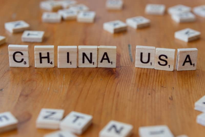 A wooden table topped with scrabble tiles spelling china