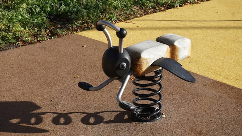 A spring rider shaped like a bee on a playground