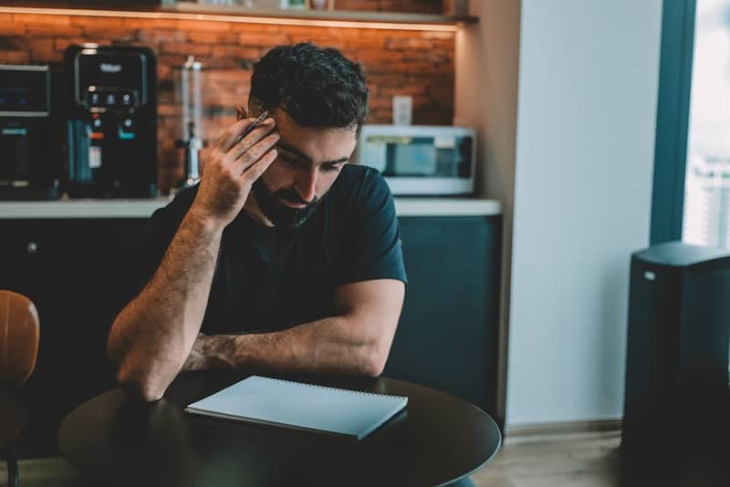 Man holding head while looking at document