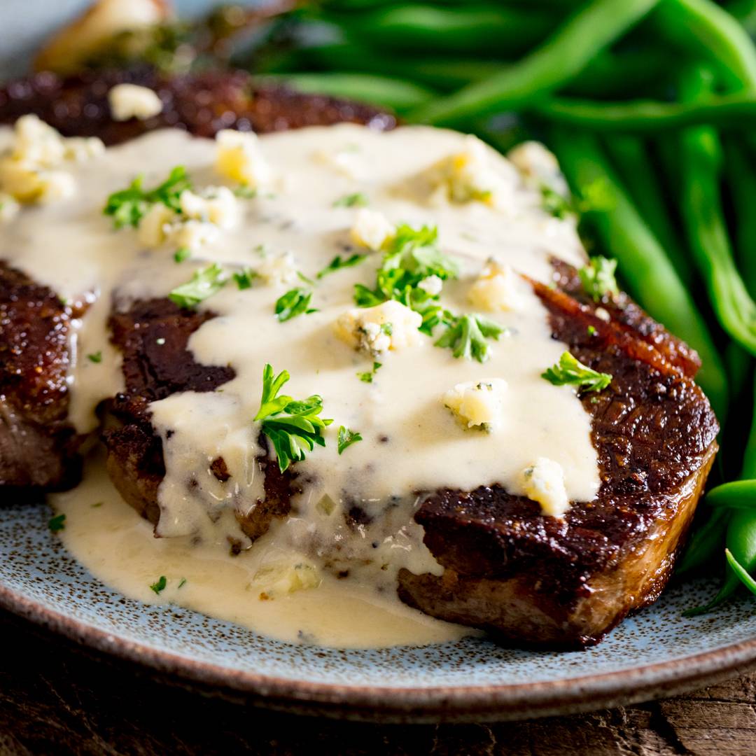 Blue cheese sauce over a steak.