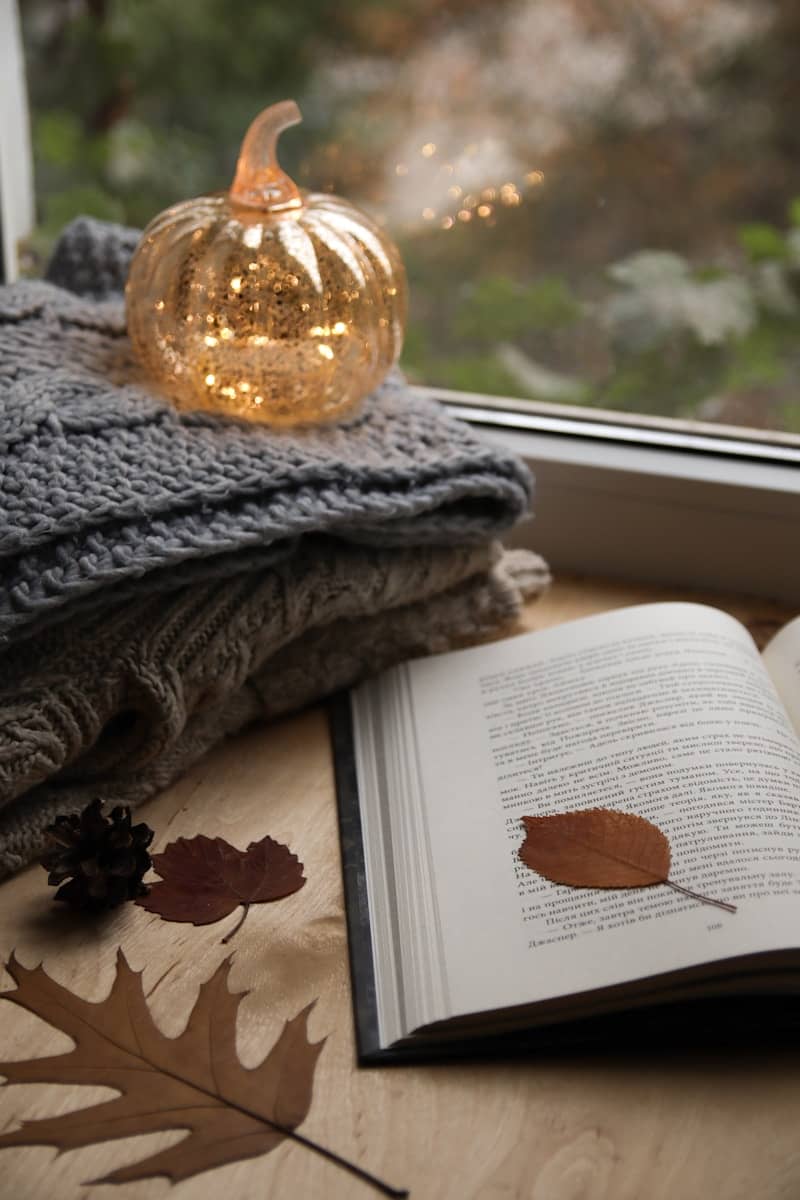 An open book sitting on top of a table next to a window