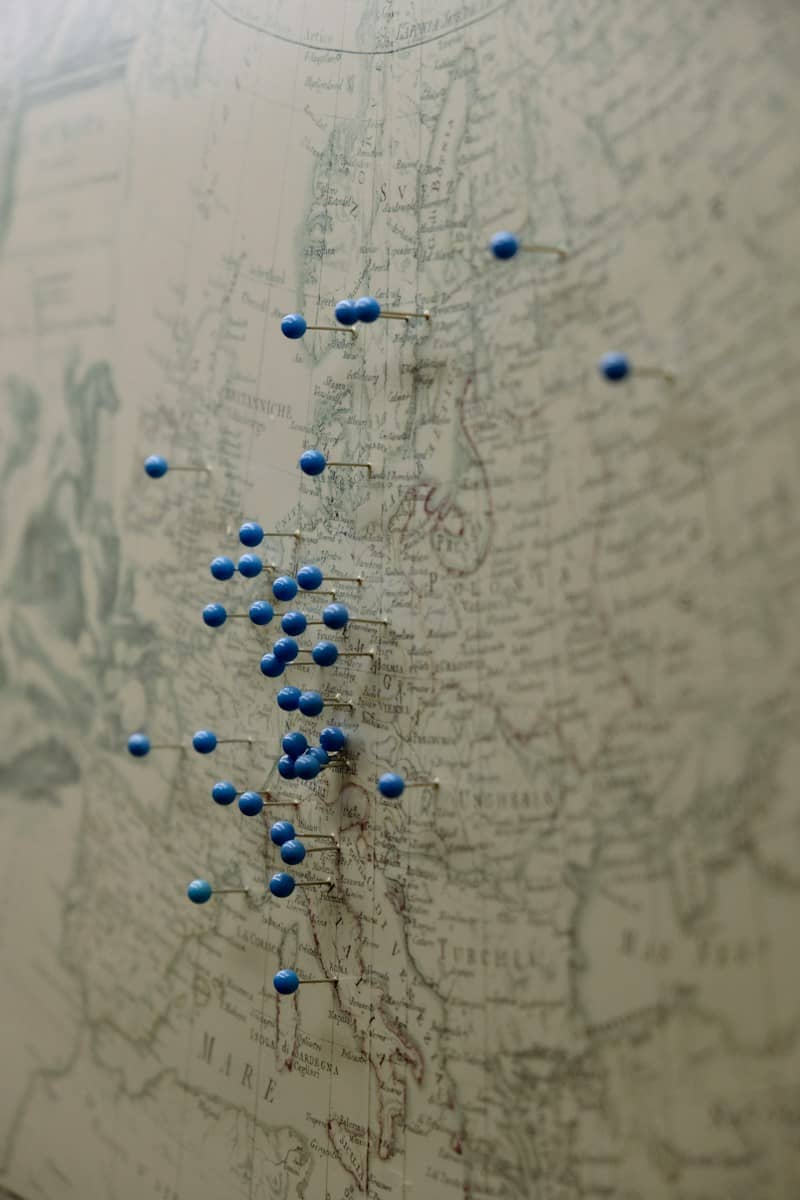 A vintage map of Europe marked with many blue push pins